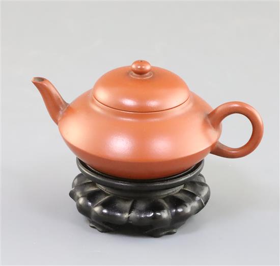 An inscribed Yixing teapot, late 19th/early 20th century, 10.2cm across, wood stand, small chip to spout